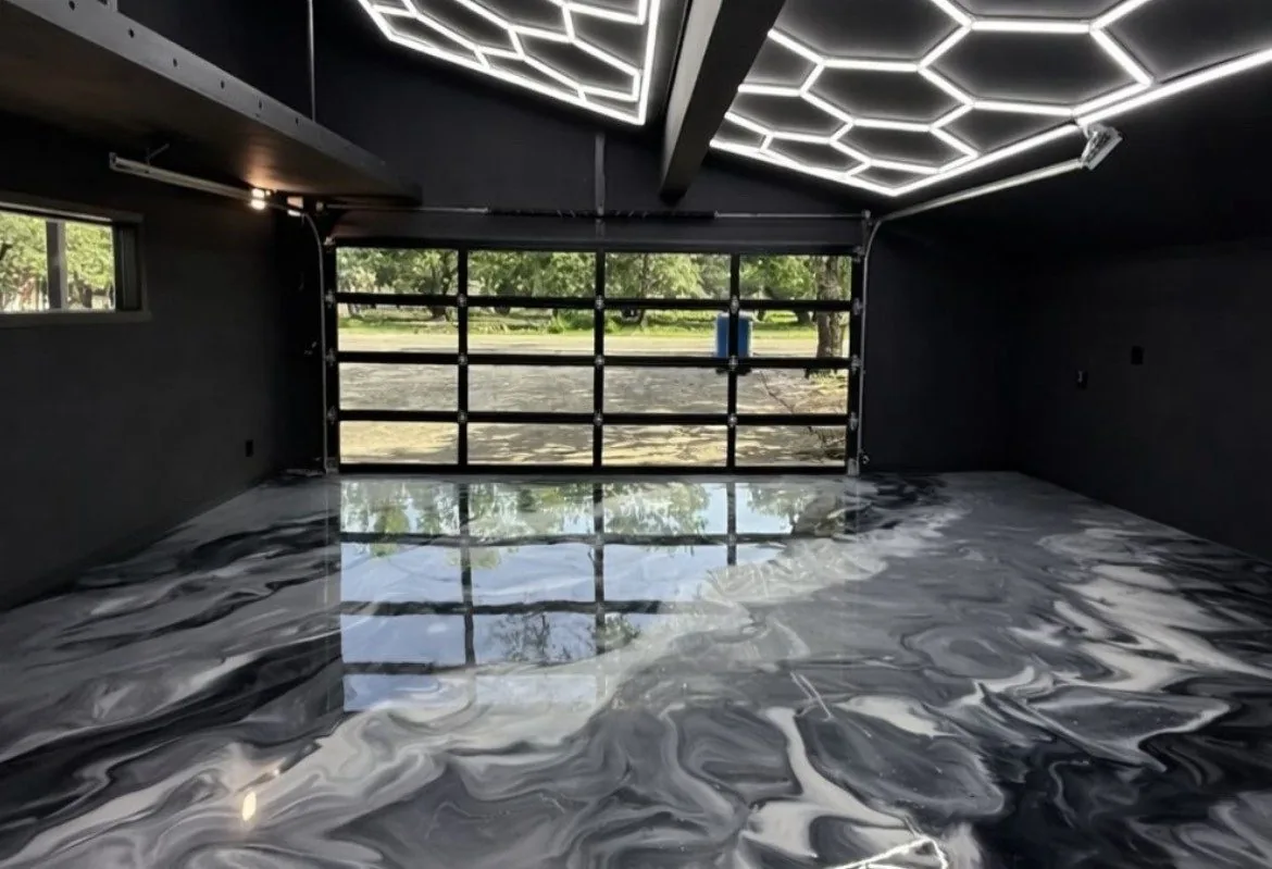 Dark metallic epoxy garage floor poured by I Do Floors & Co, reflecting a glass panel door
